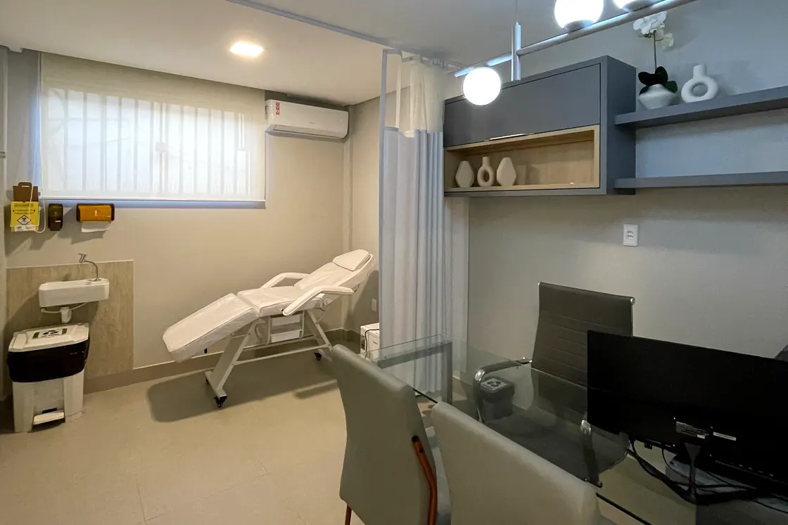 Consultório da Clínica Bem-Estar, com a mesa de atendimento e a maca