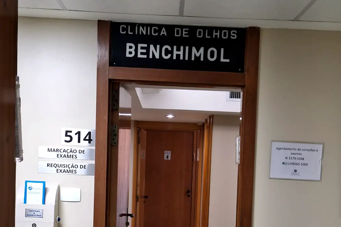 Entrada da Clínica de Olhos Benchimol, com a placa da clínica sobre a porta e o corredor dos consultórios