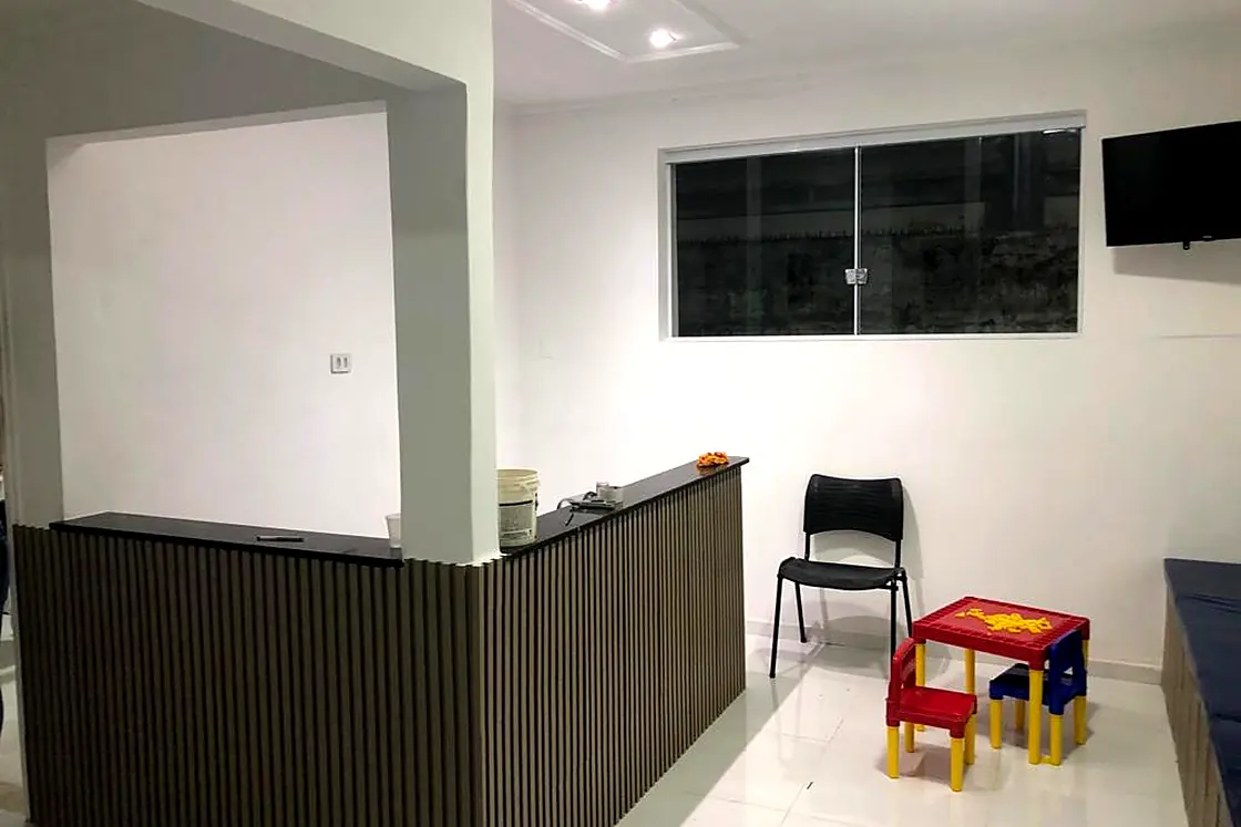 Recepção da Clínica Mais Med, com o balcão e o canto das crianças