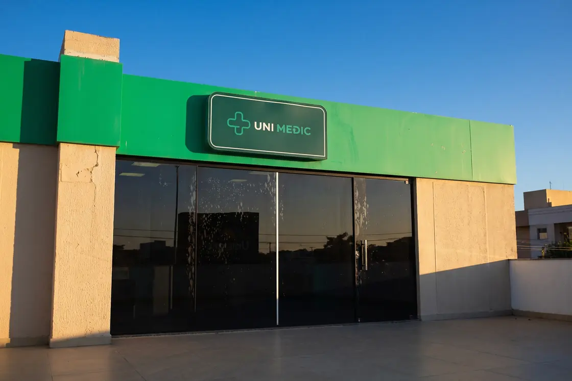 Fachada da Unimedic em Unamar, com o letreiro verde sobre a entrada de vidro
